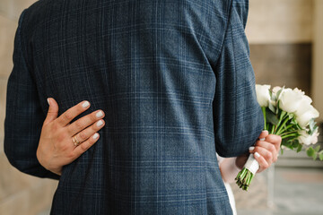 Engagement rings. Amazing wedding couple. Romantic wedding moment, newlyweds on the ceremony. The bride holds a wedding bouquet and hug groom. Back view. Close up.