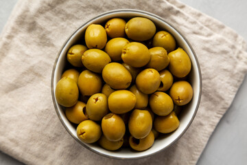 Marinated Green Pitted Olives in a Bowl, top view. Flat lay, overhead, from above.