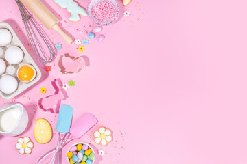 Cute pink sweet baking flat lay for Easter holiday. Cooking background with baking ingredients, rolling pin, whisk for whipping, cookie and cutters, sugar sprinkling, flour, top view copy space