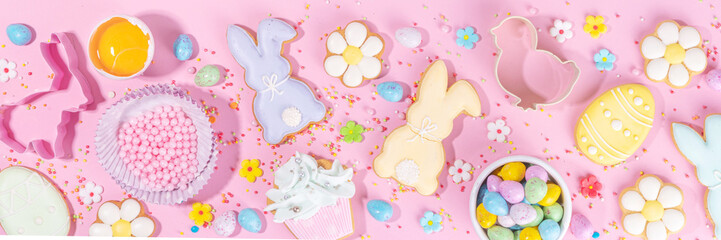 Cute pink sweet baking flat lay for Easter holiday. Cooking background with baking ingredients, rolling pin, whisk for whipping, cookie and cutters, sugar sprinkling, flour, top view copy space