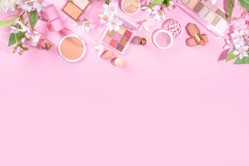 Fototapeta na wymiar Spring professional makeup flat lay. Spring make up set on pink background. Different make-up cosmetics, beauty accessories flat lay with spring blossom flowers top view copy space