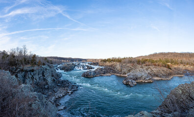 A wide-angle photo of Great Falls National Park in the winter during sunset.