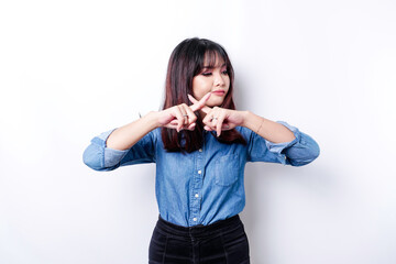 Beautiful Asian woman wearing blue shirt with hand gesture pose rejection or prohibition with copy...