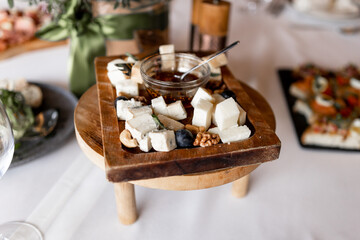 sliced ​​cheeses on a wooden plate in a restaurant on the table