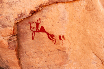 Neolithic rock art. Rock painting of a camel with rider. Tadrart Rouge. Tassili N'Ajjer National Park. Sahara Algerian Desert. Illizi Province, Djanet, Algeria, Africa    