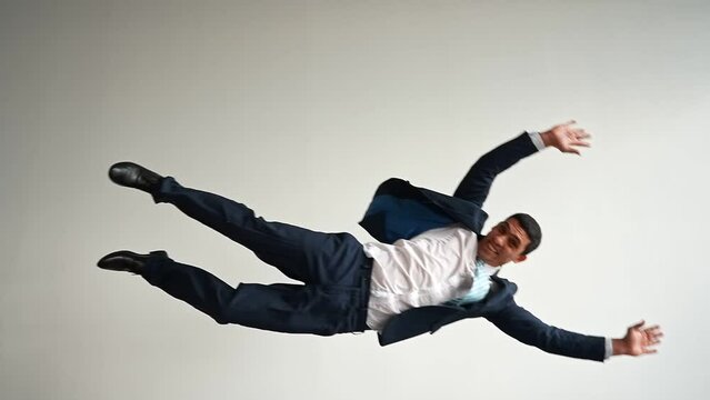 Funny Businessman in a Jacket and Tie Flies and Shouts on a White Background and Falls. Slow Motion.