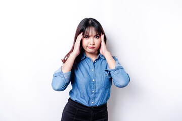 A portrait of an Asian woman wearing a blue shirt isolated by white background looks depressed