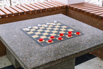A game of checkers. A house in the park for playing checkers and chess. Chess board in the winter...