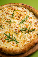 pizza with cheese on a board on a colorful green background