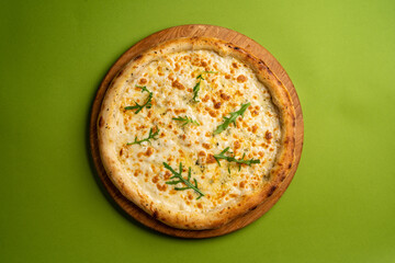 pizza with cheese on a board on a colorful green background