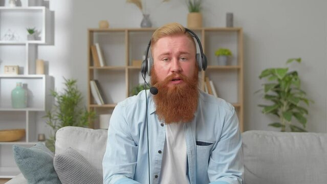 Web Camera Head Shot View Skilled Young Redhead Businessman Manager Boss In Headphones Holding Online Negotiations Meeting Using Video Call Zoom Application, Distant Communication And Modern Tech.