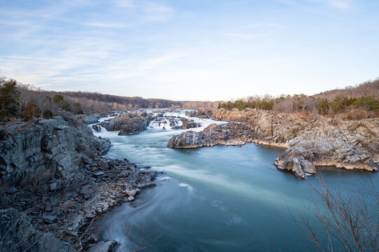 A wide angle long exposure photo of Great Falls National Park in the winter during sunset.