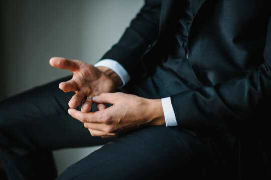 A Man Puts A Wedding Ring On His Finger. The Concept Of Cheating On A Married Man. Close Up Hands.