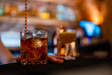 woman bartender hand making negroni cocktail. Negroni classic cocktail and gin short drink with sweet vermouth, red bitter liqueur