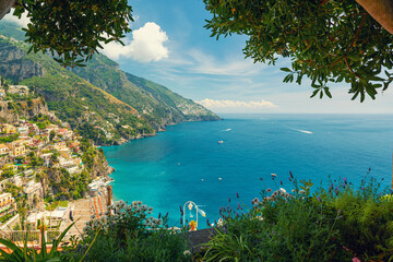 View on Italian coastal town Positano on Amalfi coast from terrace with flowers and trees,...