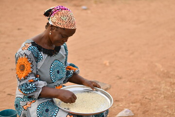 elderly african woman with a rice tray