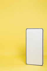 vertical view of white template of mobile phone on yellow background.