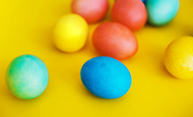Colorful Easter eggs in basket on yellow background. Family with kids preparing for Easter at home.