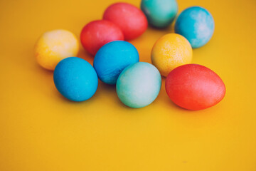 Colorful Easter eggs in basket on yellow background. Family with kids preparing for Easter at home.