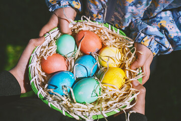 Colorful Easter eggs in basket. Kids hunt for eggs outdoors.