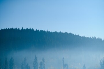 Mountain range with visible silhouettes through the morning blue fog.