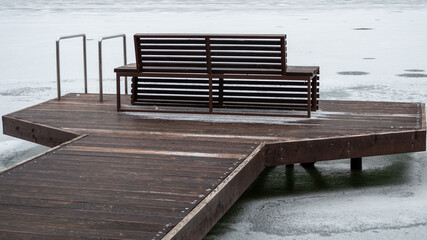 bench on a pier on a frozen lake