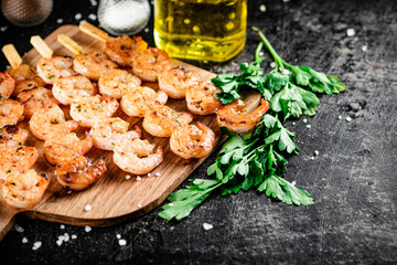 Grilled shrimp on a wooden cutting board. 