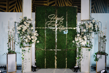 Happily ever after text. Arch, wall, photo zone, area decorated with a composition of white flowers...