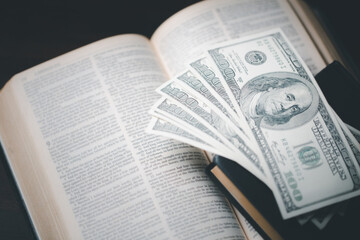 One tenth or tithe is basis on which Bible teaches us to give one tenth of first fruit to God. coins with Holy Bible. Biblical concept of Christian offering, generosity, and giving tithes in church.
