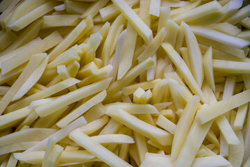 Background from potato straw. Potato background. Cut fresh potatoes into strips. Potato straw. Preparations for french fries.