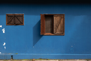 Ventana abierta en fachada azul