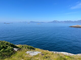 Blue calm ocean bay horizon, small rocky islands, blue sky