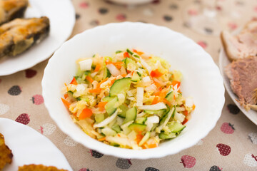 mix of vegetables. chopped cabbage, tomatoes, cucumbers, onions and greens in a bowl