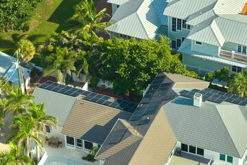 Fototapeta na wymiar Aerial view of new expensive american building roof with rows of blue solar photovoltaic panels for producing clean ecological electric energy. Renewable electricity with zero emission concept