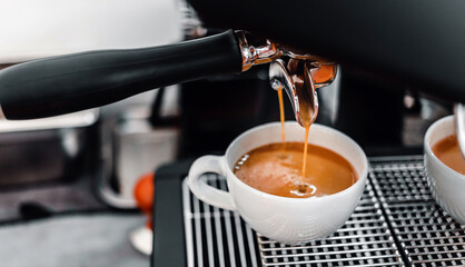 Coffee extraction from the coffee machine with a portafilter pouring coffee into a cup,Espresso poruing from coffee machine at coffee shop