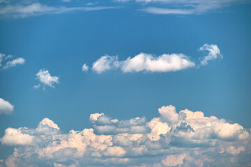 Bright landscape of white puffy cumulus clouds on blue clear sky