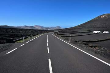 Eine Straße führt durch die Weinbauregion von Lanzarote La Geria, und führt in Richtung  einer kette von erloschenen Vulkanen