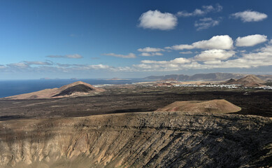 Ein Panoramablick von der Caldera Blanca über die Kanareninsel Lanzarote mit seinen Vulkanen, Lavafelder, Ortschaften bis hin zum Meer.