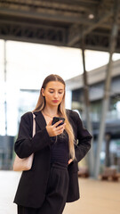 Portrait beautiful business woman walking go to working with coffee cup and using smartphone on city street