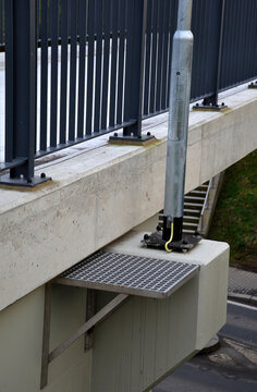railing at the bridge with vertical fence bars anchored to the ground with four concrete screws. plastic caps, cobblestone, stone, paving, cable, edge, next to, pillar, fixing, point, urban, , lawn