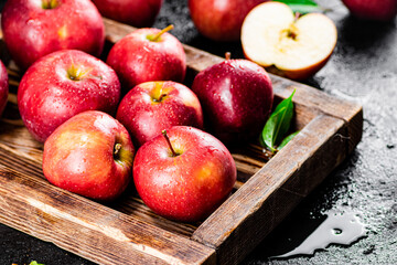 Ripe red apples on a wooden tray. 