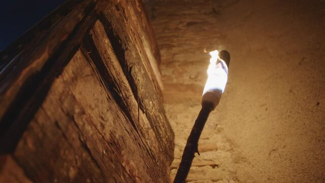fire torch on medieval wall in the night 