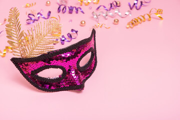 Festive face mask for masquerade or carnival celebration on colored background. Copy space