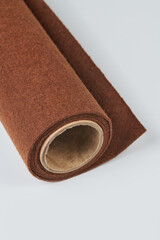 Soft felt textile material brown colors, colorful texture fabric roll closeup
