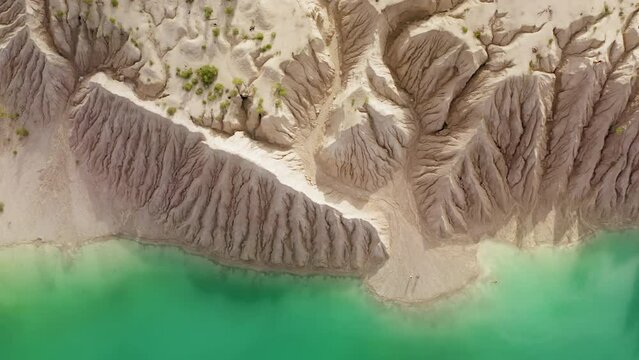 Jaw-dropping scenery of unique landscape with greenish lake. Drone footage of sandy banks of a quarry in Ukraine. High quality 4k footage