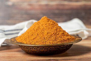 Meatball spice in bowl on rustic table. Meatball seasoning is a spice mix consisting of cumin, coriander, ground red pepper, thyme, black pepper, onion, garlic and dried parsley. Dry spice concept