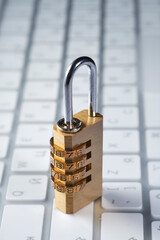 cyber security concept, golden colored combination lock on computer keyboard - obrazy, fototapety, plakaty