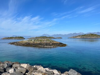 Blue calm ocean bay horizon, small rocky islands, blue sky