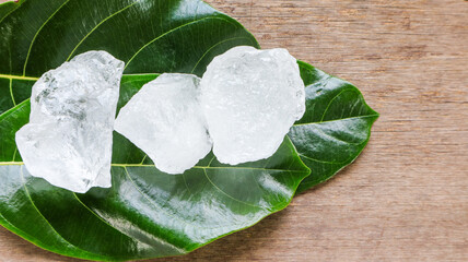 Crystal clear alum cubes or Potassium alum on green leaves chemical compound substance concept for...