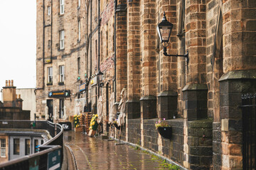 Edinburgh streets come alive in the rain, Victorian architecture standing out amidst the gloomy...